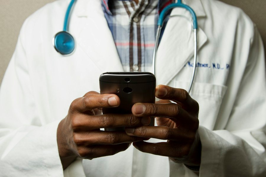 Médico com estetoscópio utilizando um celular